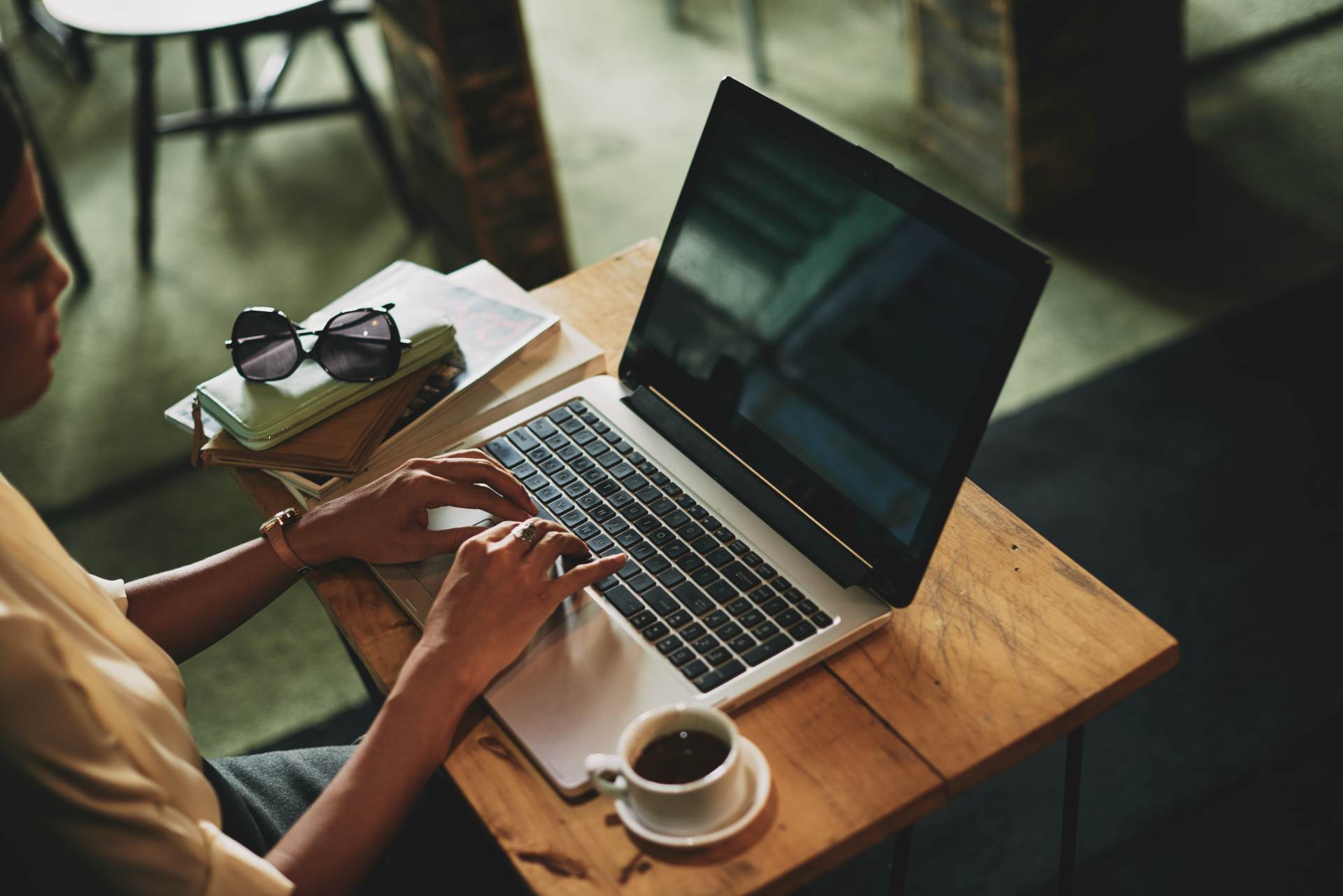 unrecognizable-asian-woman-sitting-cafe-working-laptop